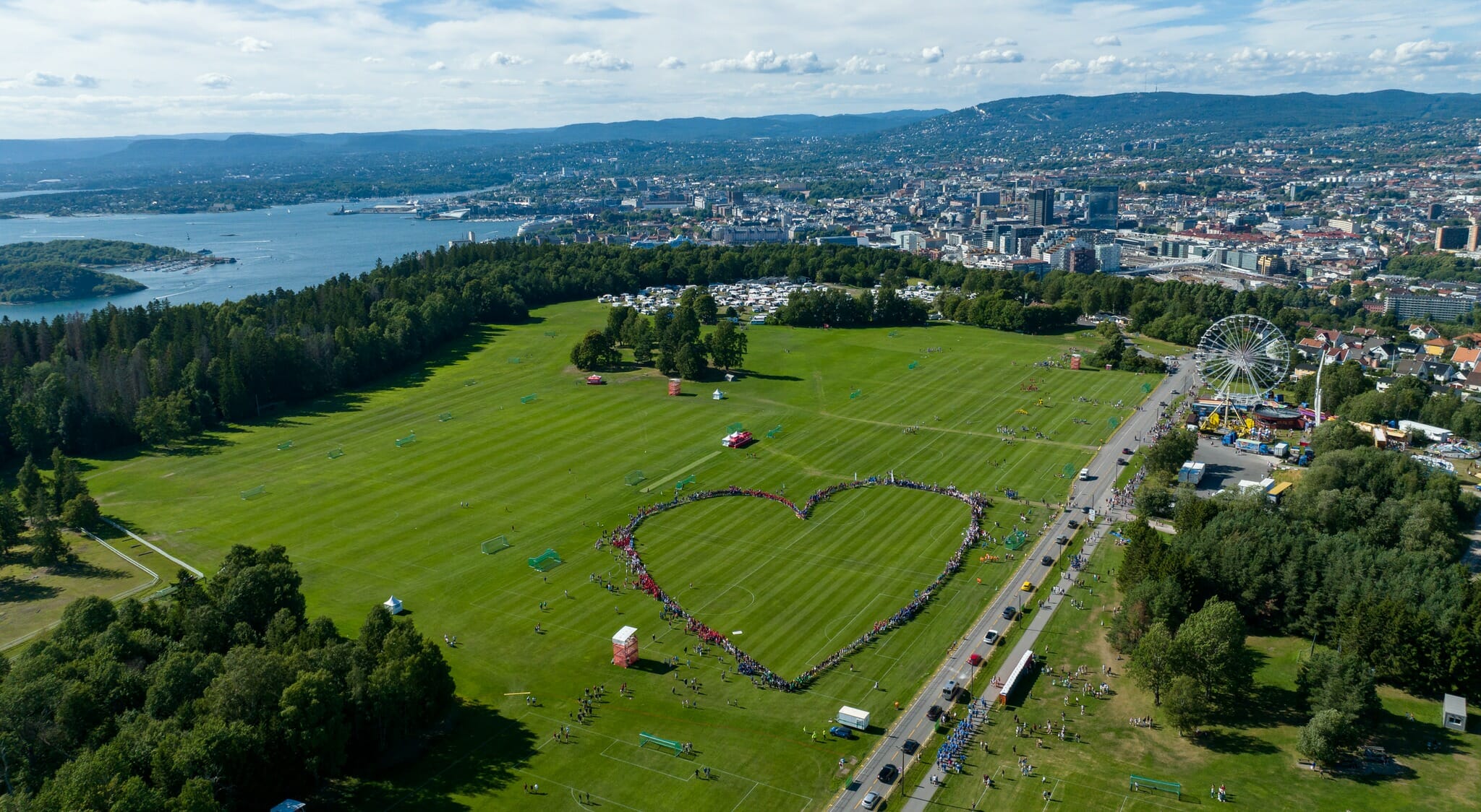 Bildet er et flyfoto som viser Ekebergsletta under Noway Cup. I bakgrunnen skimter man Oslofjorden og resten av byen. Midt på slette har hundrevis av mennesker stilt seg opp slik at de danner et stort hjerteformet symbol som er synlig fra luften.